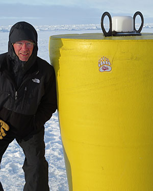 Michael DeGrandpre poses with a research buoy deployed through the ice in the Canada Basin of the Arctic Ocean. 